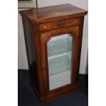 A Victorian and later walnut music cabinet with inlaid scrolling urn design, the glazed panel door