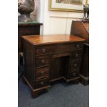 A 19th century George III style mahogany kneehole desk with rectangular shaped top and one long