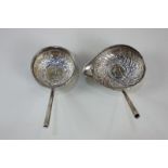 Two George II coin inset embossed white metal toddy ladles (missing handles)