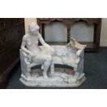 A 19th century Carrara marble statue of a nude figure seated on a bench beside two doves,
