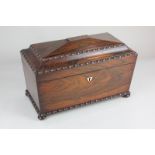 A 19th century rosewood sarcophagus shaped tea caddy with carved borders, raised on flattened bun