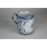 A 19th century Chinese porcelain mug with a shaped polychrome floral panel surrounded by blue and