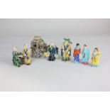 Three Chinese glazed pottery miniature figures and a model of huts on stilts, largest 9.5cm,