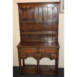 An early 20th century oak dresser, the top section with two-shelf plate rack and plank back, the
