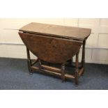 An 18th century oak gate-leg table with oval drop flaps, on turned under-frame, 108cm fully