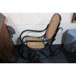 A black bentwood framed cane seated rocking chair