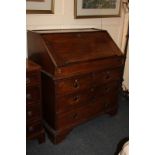 A late 18th century oak bureau in two sections, with fall front enclosing fitted interior of
