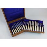 A cased set of twelve Edward VII silver dessert knives and forks with white handles, makers James