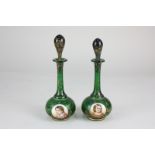 A pair of 19th century Bohemian gilt overlaid emerald glass perfume bottles and stoppers, of