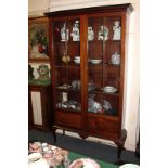 A Victorian mahogany bookcase with dentil cornice, two glazed doors, on stepped base with cabriole