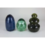 A Victorian green glass dump enclosing a flower display, 16cm, together with two glass dumps with