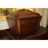 A 19th century mahogany inlaid cellaret of sarcophagus form with hinged lid and column uprights,