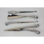A silver handled lady's dressing set of shoe horn, button hook and glove stretcher, with lion mask