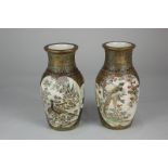 A pair of Japanese Satsuma ware vases of baluster form, decorated with panels of figures and