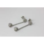 A pair of diamond drop earrings, loose hung with drop on a baton and upper link, in 14ct white gold