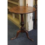 A 19th century oak occasional table with circular tilt-top on baluster turned stem on three outswept