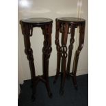 A pair of Chinese hardwood jardiniere stands, each with circular top on four pierced sinuous legs