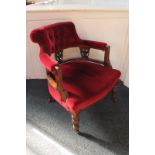 A Victorian carved mahogany framed red button upholstered tub chair on turned legs