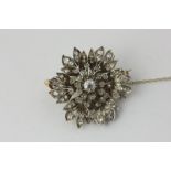 A diamond brooch of flower head design, set throughout with graduated old and rose cut diamonds in