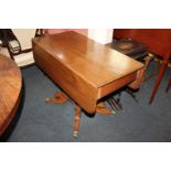 A mahogany Pembroke table with drawer and opposing dummy drawer, faceted stem on four outswept