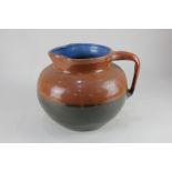 A Brannum Barum large glazed pottery jug with two-tone brown exterior and blue interior, impressed
