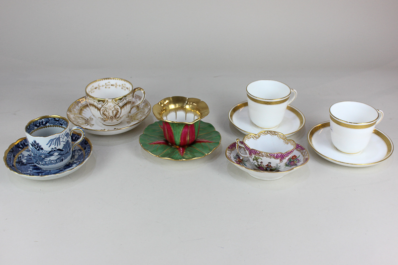 An Augustus Rex style porcelain cup and saucer with scalloped rim, decorated with vignettes of