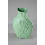 A 20th century green glazed 'Flying Saucer' vase of asymmetric form with all-over moulding of raised