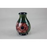 A Moorcroft pottery anemone vase of baluster form, decorated with red and purple flowers on blue-