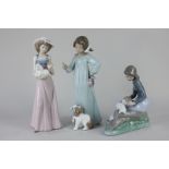 A Nao porcelain figure of a girl seated on a tree stump, with three rabbits, 19cm, together with two