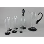 A clear and black glass part decanter set decorated with sailing ships, comprising decanter, jug,