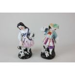 A pair of Continental porcelain figures of a girl playing with a dog, and a boy playing with a