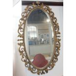 An oval wall mirror with gilt foliate frame, 73cm by 46cm