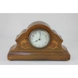 An Edwardian mantel clock in serpentine shaped inlaid case with scrolling foliate decoration, the