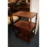 A walnut two tier whatnot, the shaped top mounted with a circular brass disc to each corner, the