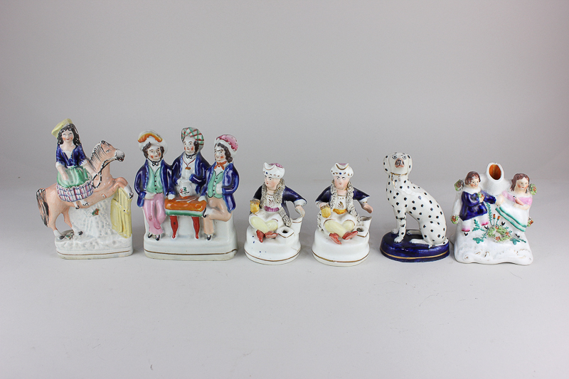 Six Staffordshire pottery figures including a flat-back of a woman on horseback, a bud vase