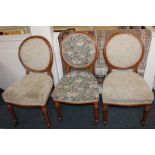 A set of three Victorian balloon back chairs with floral upholstery, on turned legs with castors,