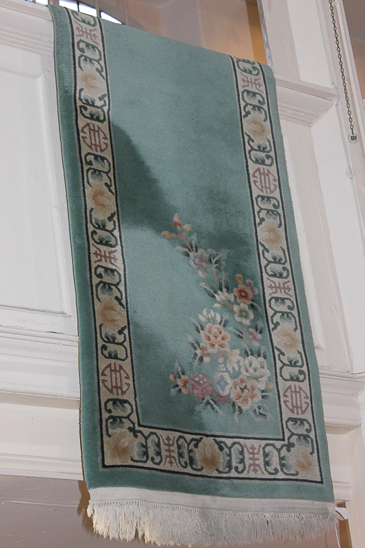 A Chinese wool runner with floral sprays and border of character marks on turquoise ground 435cm