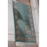A Chinese wool runner with floral sprays and border of character marks on turquoise ground 435cm