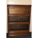 A Globe Wernicke oak three tier glass fronted bookcase, on plinth base, with The Globe Wernicke