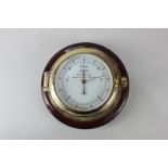 A Wempe brass cased porthole barometer, the dial marked Chronometerwerke Gegrundet 1905 Hamburg,