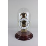 A Hermle brass skeleton clock with glass dome, 29cm high