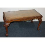 A walnut rectangular side table with inset glass top, on scroll carved cabriole legs with claw and