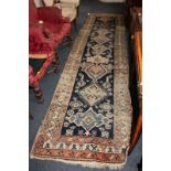 A Persian pattern wool runner, blue ground, geometric designs within multiline borders, 98cm by