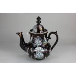 A large Victorian bargee's teapot decorated in light relief with polychrome decoration of flowers