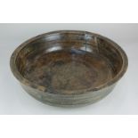 A large 18th century turned oak bowl with adze marks to base, 44cm diameter