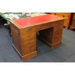 An early 20th century oak pedestal desk with rectangular red leather inset top above an