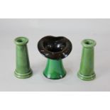 A pair of green glazed 'chimney' candlesticks of tapered cylindrical form, 12cm high, together