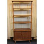 An Ercol 'Giraffe' room divider, the top shelf with spindled centre, and two further adjustable