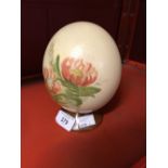 Objects of Virtu: A painted ostrich egg, decorated with flowers, mounted on a plinth.