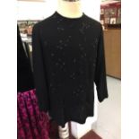 Fashion: Black crepe evening top. Long sleeves, round neck, button back fastening. Heavily trimmed